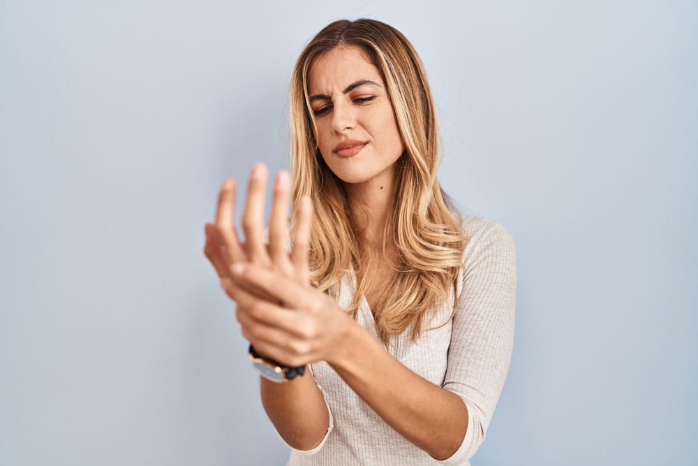 Frau mit Schmerzen in den Fingern und der Hand