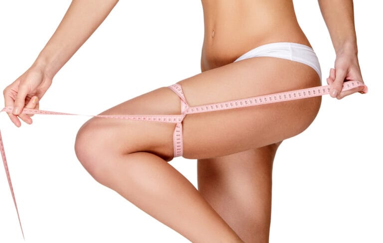 Frau mit einem Maßband um ihren Oberschenkel